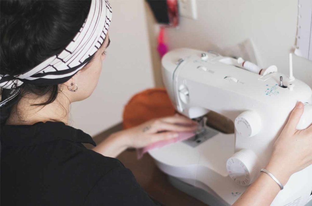 Femme portant un bandeau en train de coudre à la machine
