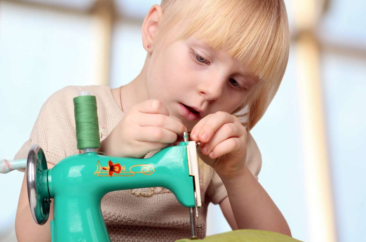 enfant qui enfile sa machine à coudre,kitac,couture débutant,apprendre à coudre,debuter en couture,machine à coudre